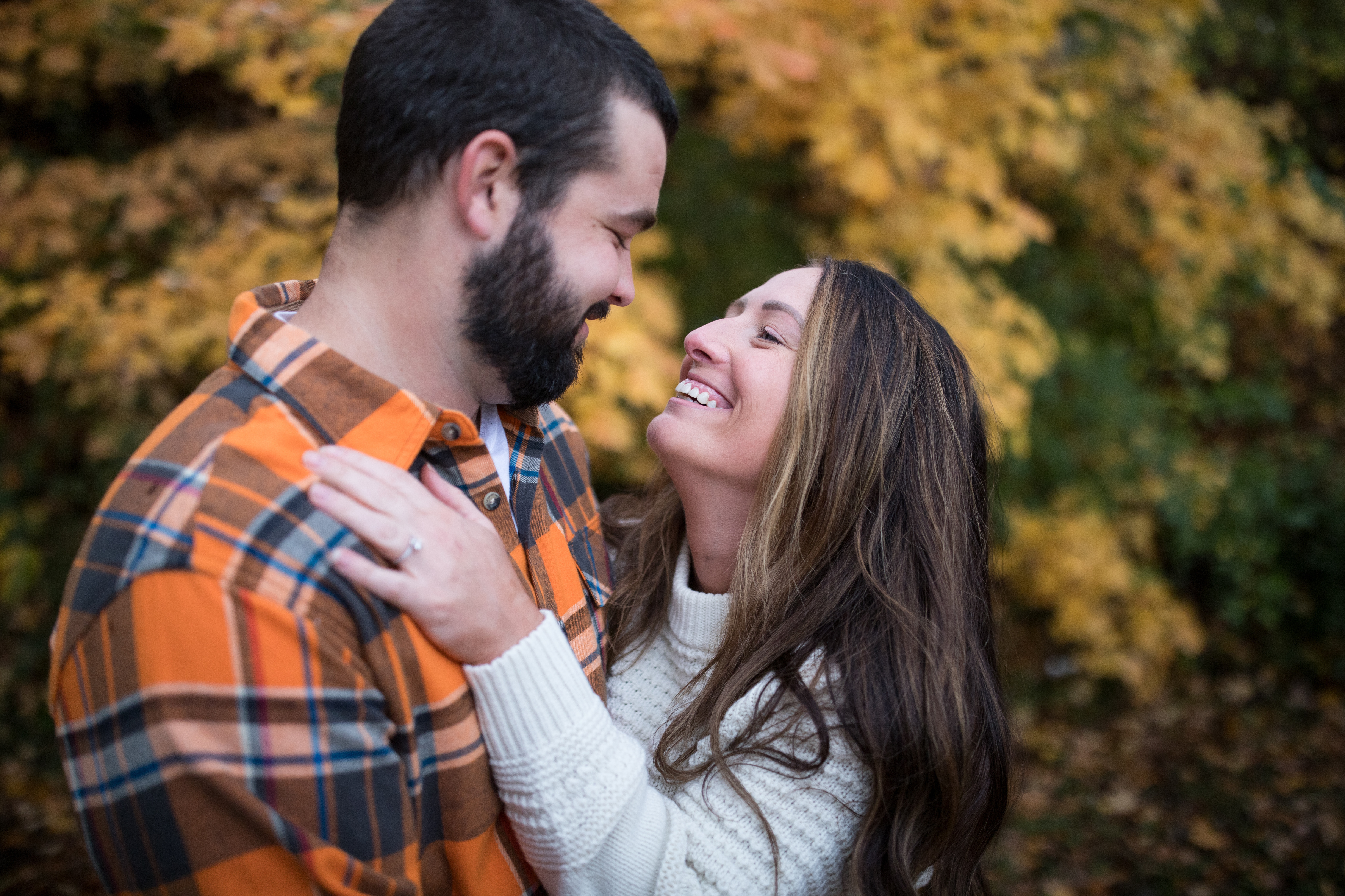 man and woman laughing in engagement photo
