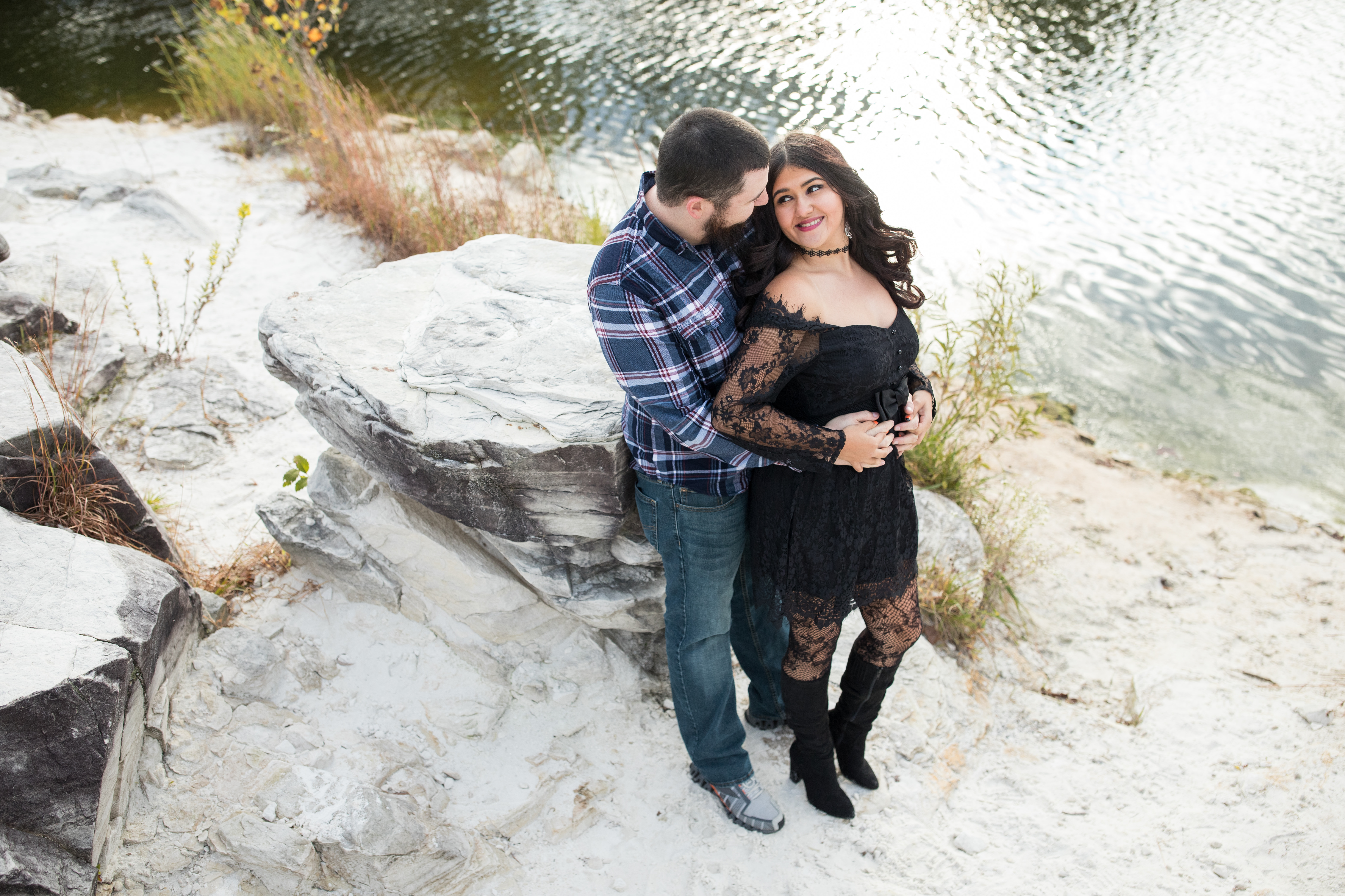 couple posing on rocky lakefront