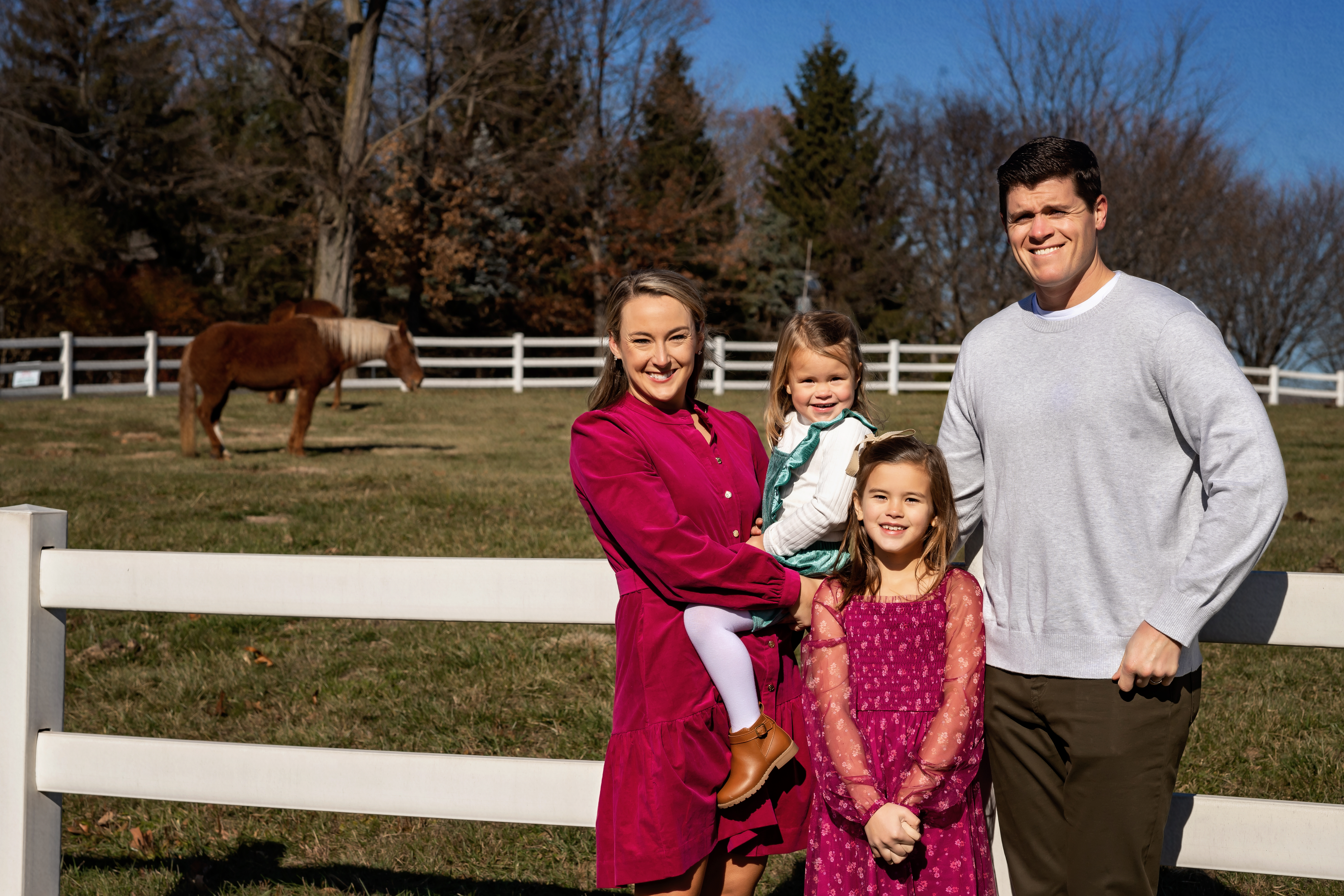 family photo with horse pasture in the background