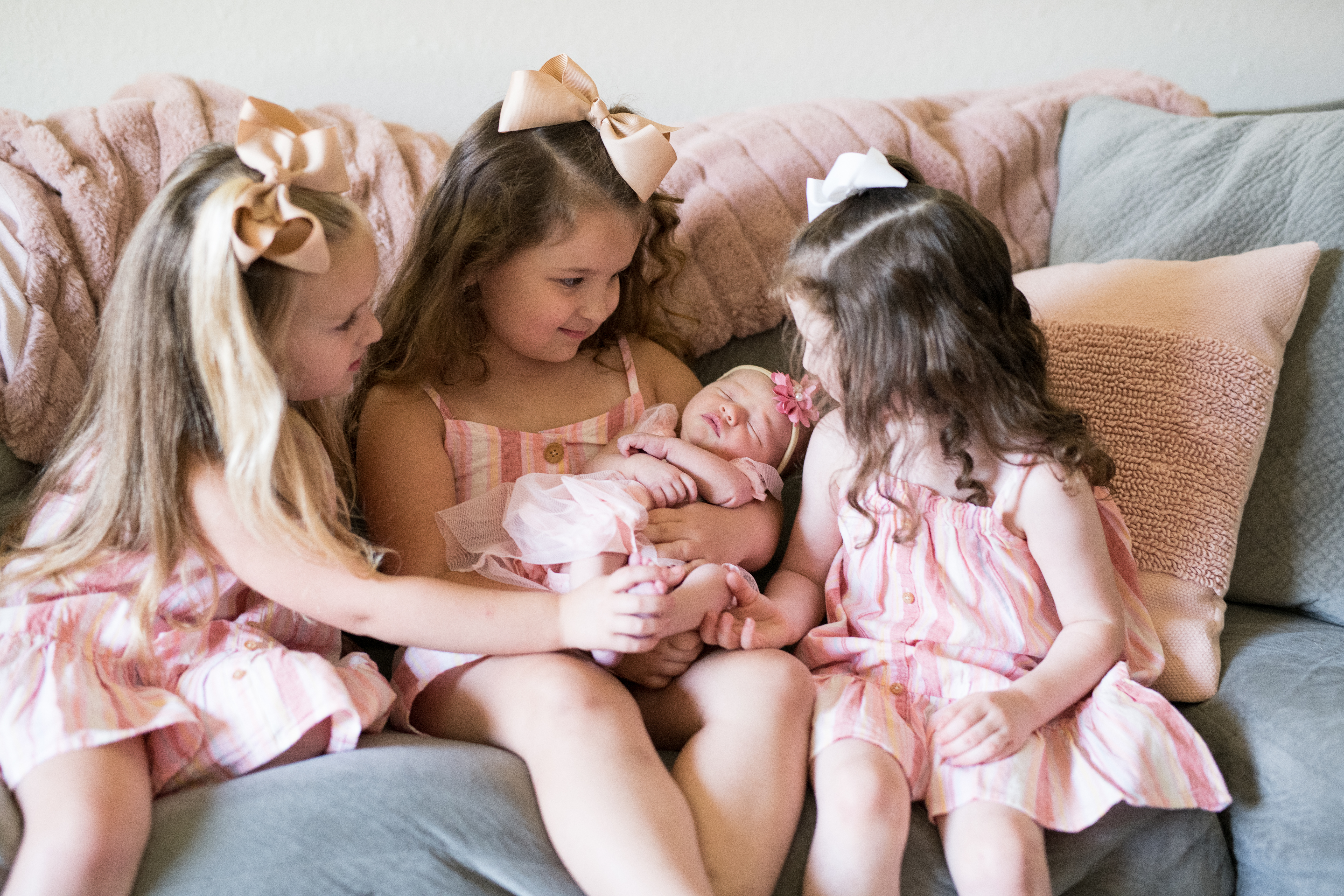 sisters holding newborn baby sister