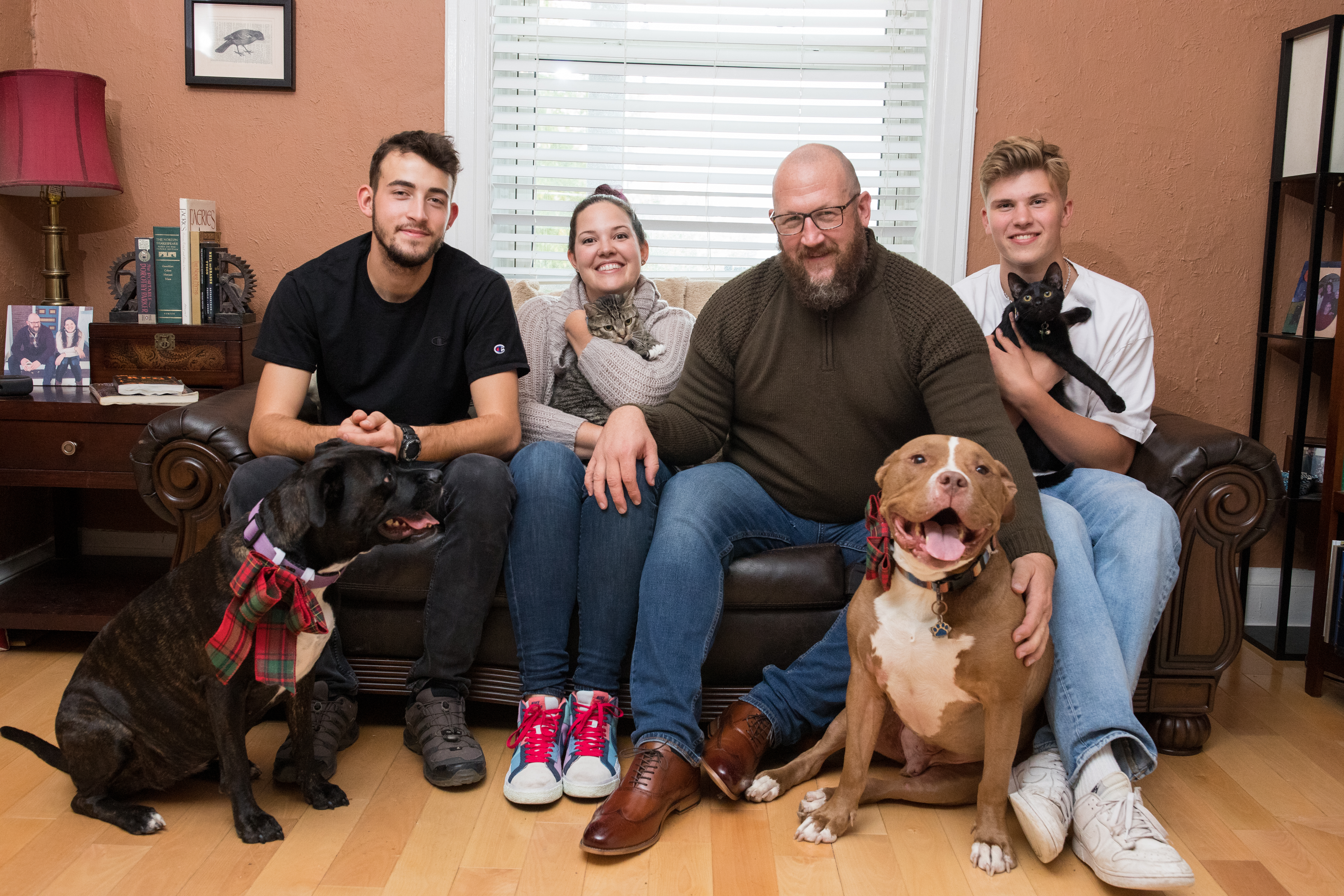 family photo on couch with their pets